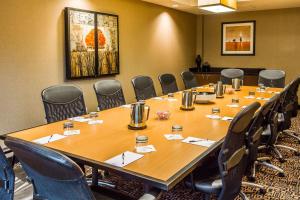 a conference room with a large wooden table and chairs at Cambria Hotel Raleigh-Durham Airport in Morrisville