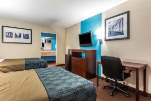 a hotel room with a bed and a desk with a computer at Econo Lodge Elizabeth City in Elizabeth City