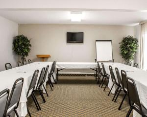 Quality Inn في روكي ماونت: قاعة اجتماعات مع طاولة وكراسي وشاشة
