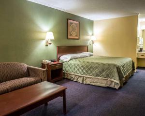 a hotel room with a bed and a couch at Rodeway Inn & Suites Plymouth Hwy 64 in Plymouth