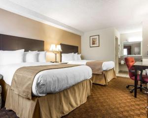 a hotel room with two beds and a desk at Quality Inn & Suites Coliseum in Greensboro +23 photos