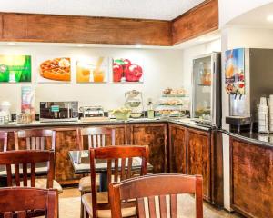 a restaurant with a counter with chairs and a table at Quality Inn & Suites Coliseum in Greensboro