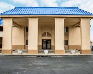 a building with a blue roof and two white pots at Rodeway Inn & Suites Plymouth Hwy 64 in Plymouth