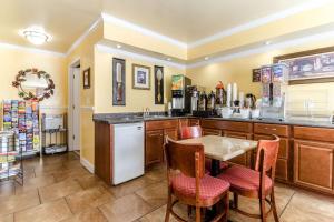 a kitchen with a counter and a table and chairs at Rodeway Inn & Suites Jacksonville near Camp Lejeune in Jacksonville