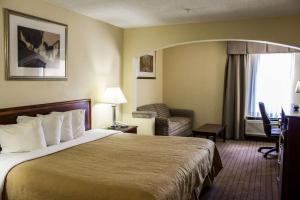 a hotel room with a bed and a couch and a window at Quality Inn Fuquay Varina East in Fuquay-Varina