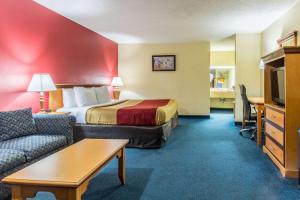 a hotel room with a bed and a couch at Econo Lodge Whiteville in Whiteville