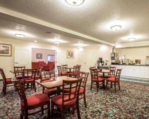a restaurant with wooden tables and chairs and a kitchen at Quality Inn Andrews in Andrews