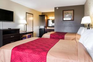 ein Hotelzimmer mit 2 Betten und einem Flachbild-TV in der Unterkunft Econo Lodge in Selma