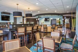 a restaurant with tables and chairs and a bar at Comfort Suites New Bern near Cherry Point in New Bern