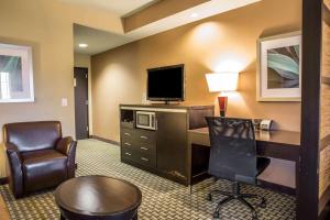 a hotel room with a desk with a television and a chair at Comfort Suites New Bern near Cherry Point in New Bern