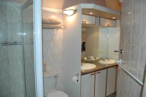 een badkamer met een toilet, 2 wastafels en een douche bij Bon A Vie Self-catering and b&b Gonubie Full Solar Power, no load shedding! in Gonubie