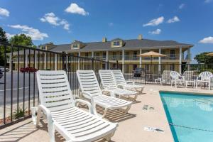 a row of white chairs next to a swimming pool at Quality Inn Laurinburg in Laurinburg