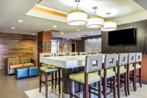 a bar in a restaurant with chairs and a tv at Comfort Inn & Suites Kannapolis - Concord in Kannapolis