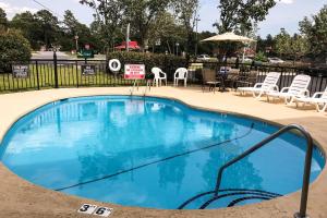 a large blue pool with chairs and an umbrella at Quality Inn Raeford in Raeford