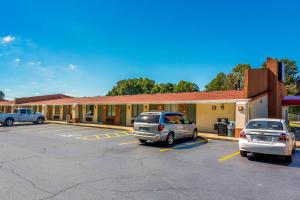 zwei Autos auf einem Parkplatz vor einem Motel geparkt in der Unterkunft Econo Lodge - Gastonia in Gastonia