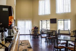 Quality Inn & Suites Wilson في ويلسون: غرفة طعام مع طاولات وكراسي ونوافذ