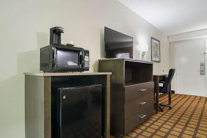 a microwave sitting on top of a table with a desk with a microwave at Quality Inn Raeford in Raeford