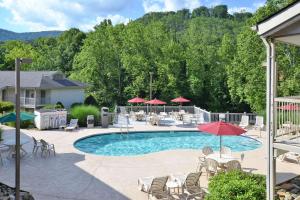 a swimming pool with chairs and tables and umbrellas at Quality Inn Cherokee Riverside in Cherokee