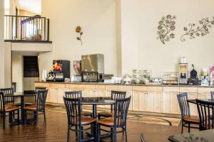 Quality Inn & Suites Wilson في ويلسون: مطعم بطاولات وكراسي وكاونتر