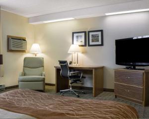 a hotel room with a bed and a desk and a television at Quality Inn Bismarck in Bismarck