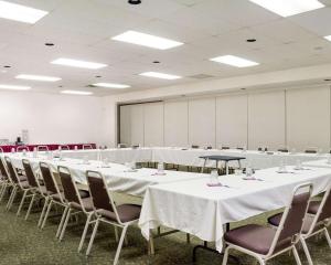 une salle de conférence avec des tables et des chaises blanches dans l'établissement Quality Inn Bismarck, à Bismarck