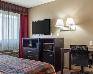 a hotel room with a bed and a desk and a television at Econo Lodge in Jamestown