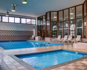 - une grande piscine avec des chaises dans un bâtiment dans l'établissement Rodeway Inn Columbia Mall Loop, à Grand Forks