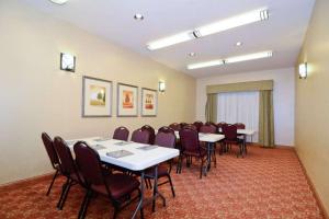 a conference room with white tables and chairs at Heritage Hotel and Suites in Dickinson