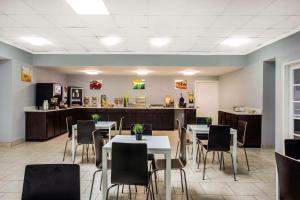 a dining room with tables and chairs and a counter at Quality Inn & Suites University Area in Charlotte