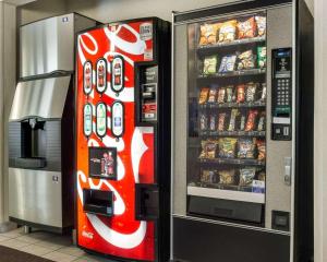 un distributore automatico di coca cola accanto a un frigorifero di Comfort Inn a Jamestown