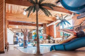 a indoor pool with a palm tree and a slide at Comfort Inn in Dickinson