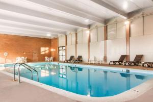 a large swimming pool with blue water in a building at Comfort Inn & Suites Omaha Central in Omaha