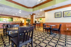 a restaurant with tables and chairs and a bar at Quality Inn in Lumberton