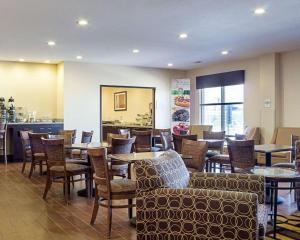 a restaurant with tables and chairs and a bar at Quality Inn & Suites Minot North in Minot