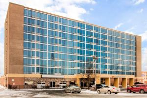 un grande edificio in vetro con auto parcheggiate in un parcheggio di Comfort Inn & Suites Omaha Central a Omaha