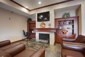 a living room with leather furniture and a fireplace at Heritage Hotel and Suites in Dickinson