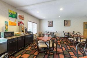 a dining room with tables and chairs and a kitchen at Quality Inn Kearney in Kearney