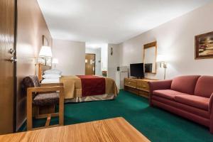 Habitación de hotel con cama y sofá en Rodeway Inn Holdrege, en Holdrege