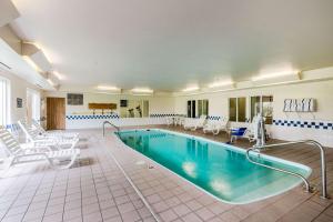 a large swimming pool with white chairs and a swimming pool at Quality Inn Kearney in Kearney