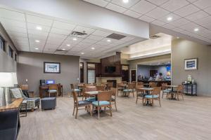 a restaurant with wooden tables and chairs and a bar at Comfort Inn SW Omaha I-80 in Omaha