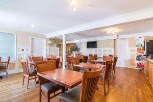 Quality Inn North Conway في نورث كونويه: غرفة طعام مع طاولات وكراسي خشبية