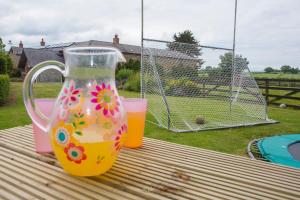 zwei Glasvasen auf einem Tisch mit einem Drink in der Unterkunft Decoy Country Cottages in Navan