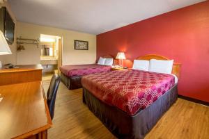 Habitación de hotel con 2 camas y pared roja en Econo Lodge, en Mount Laurel