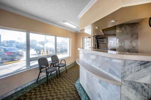 a bar with two chairs in a room with a window at The Boards AC in Atlantic City