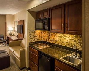 a kitchen with a sink, stove, microwave and dishwasher at Quality Suites NYC Gateway in North Bergen