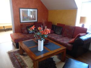 a living room with a couch and a table with flowers at Rosa Huset Osebol in Stöllet