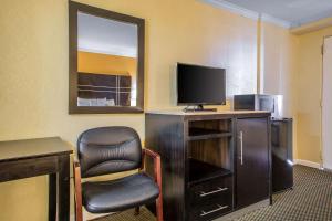 Habitación con escritorio, silla y TV. en The Boards AC en Atlantic City