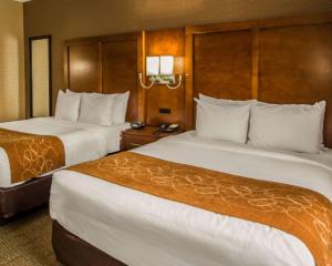 a hotel room with two beds and two lamps at Quality Suites NYC Gateway in North Bergen