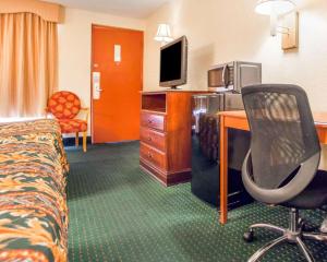 a hotel room with a bed and a desk with a television at Rodeway Inn Mount Laurel Hwy 73 in Mount Laurel