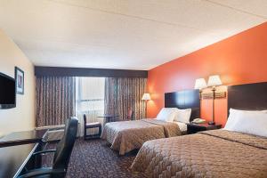 a hotel room with two beds and a television at Rodeway Inn Meadowlands in Secaucus